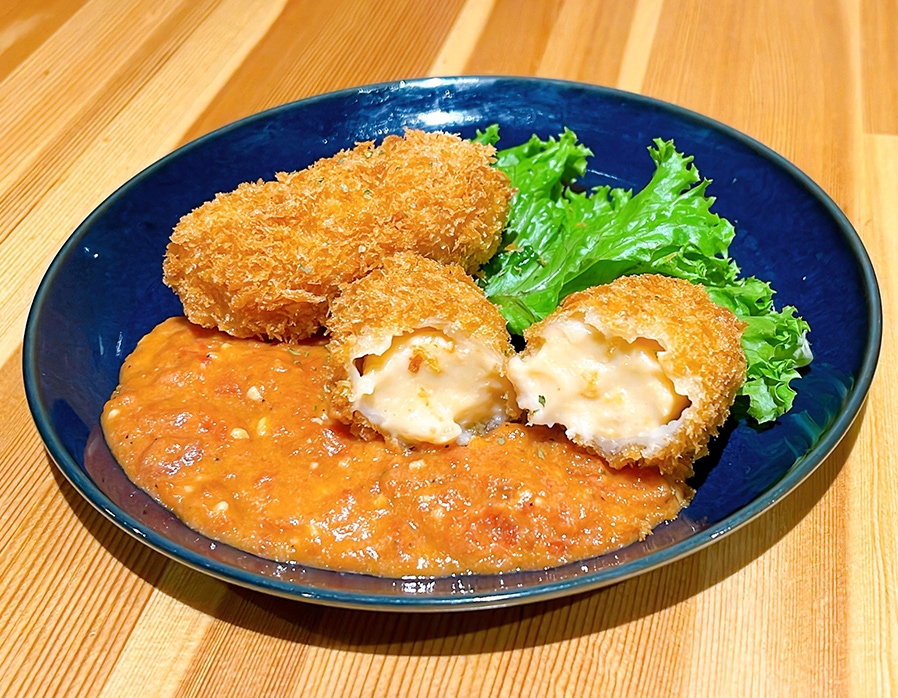 カニクリームコロッケのエビクリームソースの写真